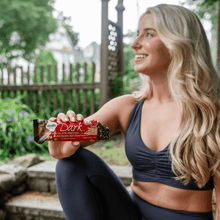 Load image into Gallery viewer, Woman eating Dark Chocolate Pretzel bar close up
